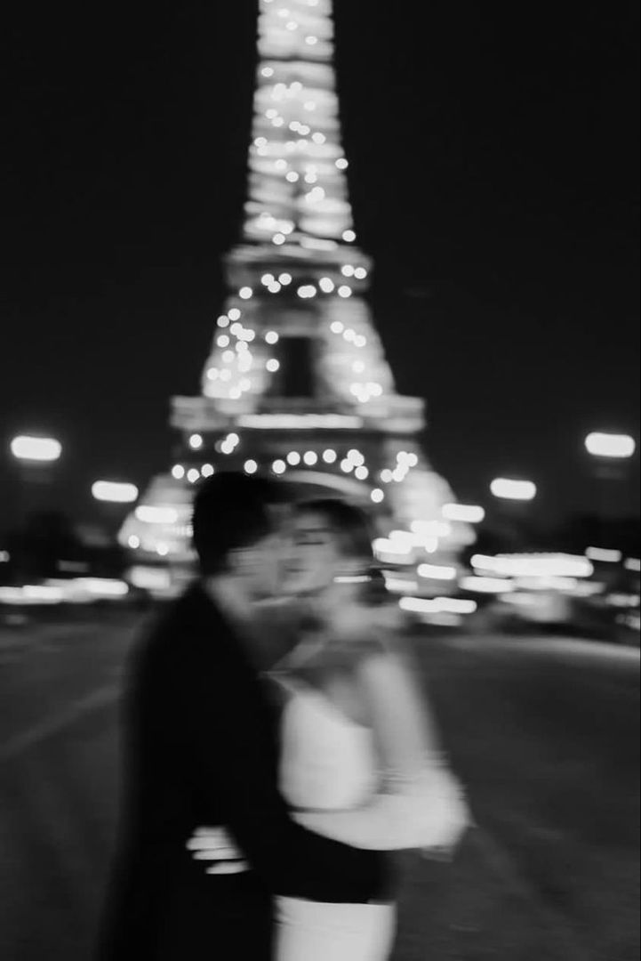 Pareja frente a la torre Eiffel de noche, en blanco y negro